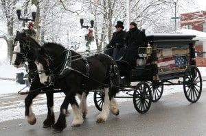 A horse-drawn hearse carrying the flag-covered casket of Edd Kueker makes its way up Main Street from Immanuel Lutheran Church to Kolmer Memorial Cemetery in Waterloo on Saturday morning. (Kermit Constantine photo)