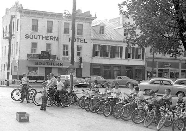 Early 1950s Main Street in Waterloo was home to a variety of businesses and residences, and served as the playground for a generation of youth. Pictured, the Waterloo Optimist Club holds a bicycle inspection on Main Street in 1954 against the backdrop of the Southern Hotel (now Subliminal Subs). (Bob Voris photo)