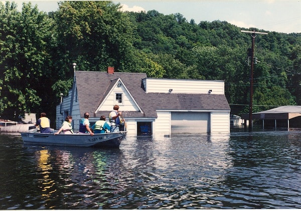 The U.S. Coast Guard took owners into the flooded town of Valmeyer to look at their property in early August. Pictured, residents pass Mike and Laurie Brown’s gas station and auto repair shop, located on the east side of town. More photos of the flood are on page 6A. (Photo courtesy of Dennis Knobloch)