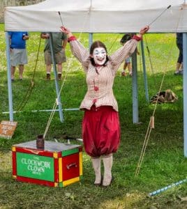 At left, a colonial-period clown performs Sunday at Rendezvous on the Fort de Chartres grounds. At right, a six-piece old-time string band performs during Rendezvous. (Alan Dooley photos)