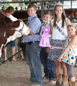 Pictured, from left, Lucas Stumpf receives the trophy for grand champion all breed heifer during judging July 2015 at the Monroe County Fair while his brother Cory proudly stands next to him along with 2015 Monroe County Fair Queen Micki Brinkmann and 2015 Little Miss Monroe County Fair Ellie Day. 