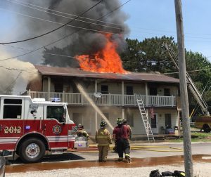 Flames are seen shooting through the roof of an apartment complex on Lindemann Avenue in Dupo on Wednesday. (Sean McGowan photo)