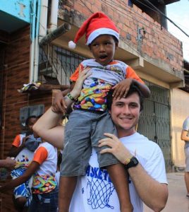 Gutknecht holds up a child on his shoulder during Christmas time in an impoverished area of Salvador. (submitted photo)