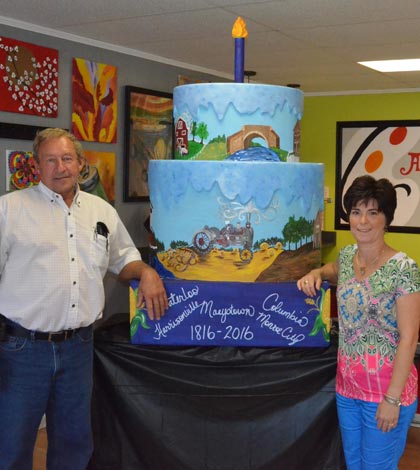 Pictured, from left, are Monroe County Commissioner Delbert Wittenauer and Theresa O'Bryan of Art2Go Studio in Columbia with the second of two ceremonial Bicentennial cakes. (Corey Saathoff photo)