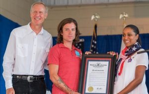 At center, Songs4Soldiers founder Dustin Row of Columbia receives the Illinois Veterans’ Patriotic Volunteer and BUSINESSAppreciation Award from Governor Bruce Rauner (left) and Erica Jeffries of the Illinois Department of Veterans' Affairs at the Illinois State Fair on Sunday. (submitted photo)