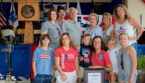 On hand during the presentation of the Illinois Veterans’ Patriotic Volunteer and Business Appreciation Award to Songs4Soldiers at the Illinois State Fair include, front row, from left, Ayden Wittenbrink, Teresa Hencke, Charlie Row, Dustin Row, Eva Row and Riley Amos; back row: Marion Chartrand, Dan Row, Ralph and Karen Buettner, Debbie Row and Katie Amos. (submitted photo)