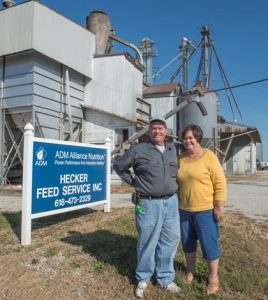 Gary and Joan Wittenauer pose in front of Hecker Feed Service, which they have reluctantly ended after 60 years and two generations of supporting farming in the region. (Alan Dooley photo)