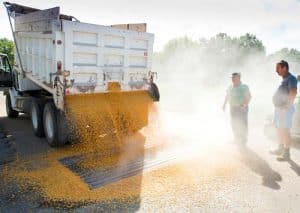 Harvesting is a dusty job, and delivering the product to market is the same. Pictured, John Schneider (right) watches as corn just harvested from his farm pours from his truck into the grain elevator in Waterloo. Gateway FS employee Dave Reichert of Columbia stands by to ensure the operation is conducted safely. (Alan Dooley photo)