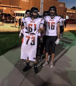 Waterloo football player Spencer Woodall holds the jersey of his late older brother, David, as he prepares to lead the Bulldogs onto the field Friday night at Mater Dei. (submitted photo)