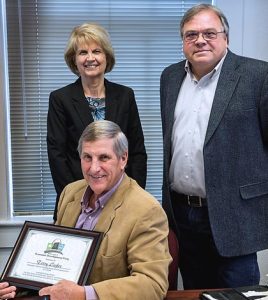 Monroe County Economic Development Corporation Executive Director Edie Koch and board chairman Jim Hill present soon-to-retire county board chairman Terry Liefer with a certificate of appreciation from the group. 