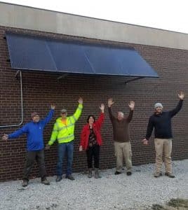 Pictured in front of the greenhouse are, from left, Chuck Witthaus of StraightUp Solar, Joshua Adams of Clinton Electric, Gibault biology teacher Karen Asbury, Gibault maintenance supervisor Mark Cranage and Matt Reuscher of StraightUp Solar. (submitted photo)