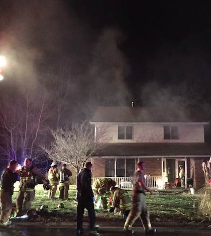 Pictured, Columbia firefighters work to extinguish a fire and ventilate smoke Tuesday night at a home on Oak Tree Drive. (Corey Saathoff photo) 