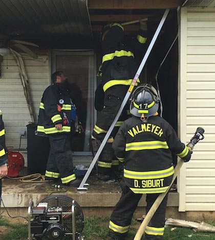 Valmeyer firemen work on the scene of a fire at 113 E. Woodland Ridge late Thursday morning. (Sean McGowan photo)