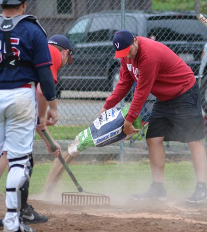 Valmeyer Lakers players served as groundskeepers during the Midsummer Classic at Borsch Park. Pictured, the grounds crew works feverishly to apply diamond dry during Saturday's game between Millstadt and Cape Girardeau. (Corey Saathoff photo)