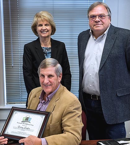 Monroe County Economic Development Corporation Executive Director Edie Koch and board chairman Jim Hill present soon-to-retire county board chairman Terry Liefer with a certificate of appreciation from the group.