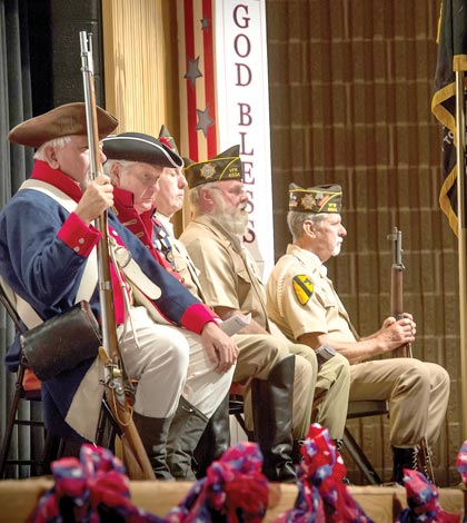 Revolutionary War re-enactors and members of the Waterloo VFW Post 6504 Color Guard listen to guest speaker Col. Laura Lenderman during the Veterans Day program at Waterloo High School on Thursday. (Alan Dooley photo)