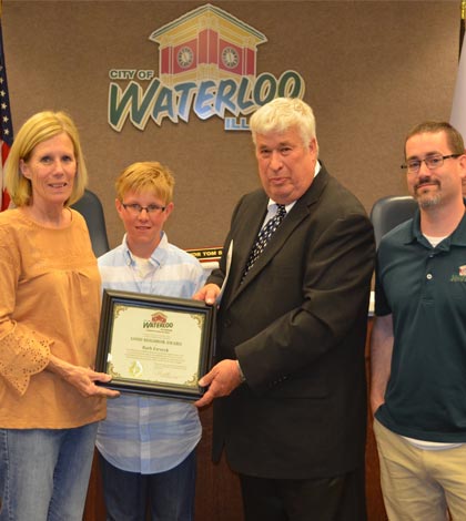 From left, Barb Zarzeck receives the Good Neighbor Award from "Mayor for the Day" Grant Lohberg, Waterloo Mayor Tom Smith and Alderman Russ Thomas. (Corey Saathoff photo)