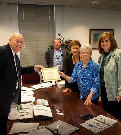 Pictured, from left, Monroe County Board Chairman Bob Elmore, with commissioners Delbert Wittenauer and Vicki Koerber looking on, presents a certificate of recognition to retiree Carla Deterding for her many years of service to Oak Hill, with Oak Hill director Kim Keckritz at her side. (Alan Dooley photo)
