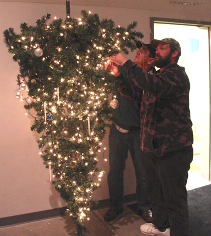 Pictured, from left, Dave dudley and Brian Offerman put the finishing touches on one of the trees on display at this year’s Christmas Tree Walk. (Sean McGowan photo)