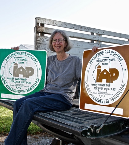 Pictured, Sandra Dannehold showcases the signs she received for her farms being named Centennial and Sesquicentennial Farms in Illinois. (Kermit Constantine photo)