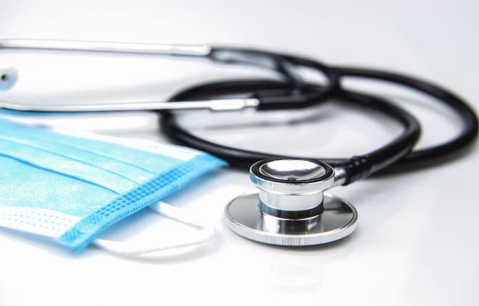 Closed up Stethoscope and Blue Surgical Mask on White Background