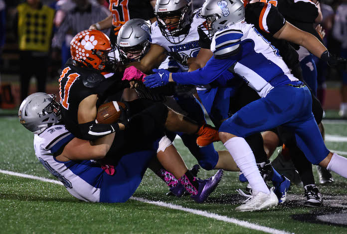 Koby Osterhage runs the ball against Freeburg  and is gang tackled by the Midgets at Waterloo High School on Friday, October 20, 2023. Paul Baillargeon