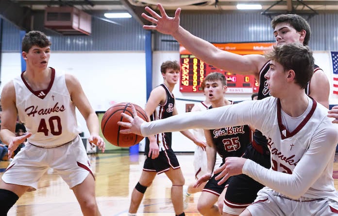 Gavin Kesler (32) of Gibault drives to the basket then throws a pass to Peyton Schaefer (40) against Red Bud in a game on Saturday, January 27, 2024 at Gibault High School in Waterloo, Illinois.