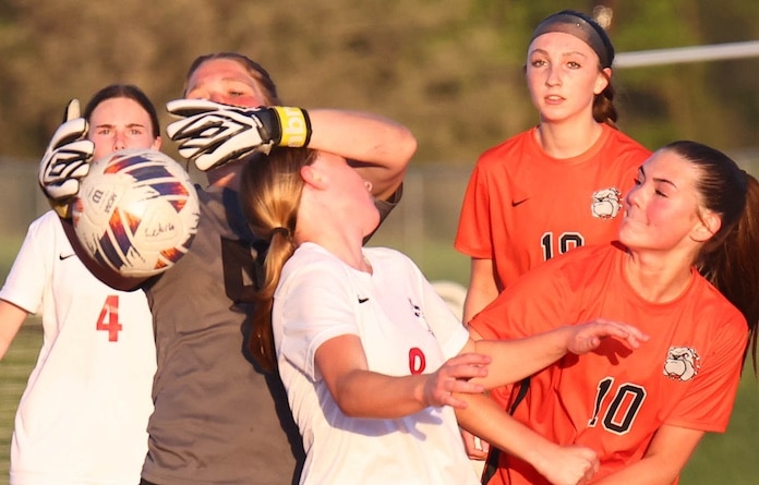 Makayla Gummersheimer (00) goalie for Waterloo reaches to grab the ball as Peyton Keleletc (8) looks to score for the Hawks in a soccer match at Waterloo High School on Monday April 21, 2025.