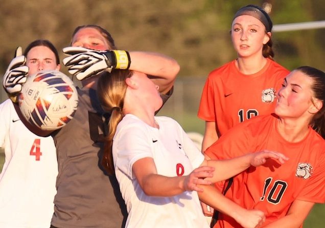 Makayla Gummersheimer (00) goalie for Waterloo reaches to grab the ball as Peyton Keleletc (8) looks to score for the Hawks in a soccer match at Waterloo High School on Monday April 21, 2025.